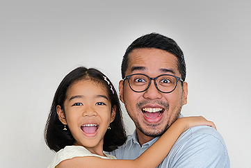 Dad wearing glasses with child, both with excited happy expressions