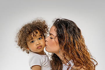 Mother kissing child
