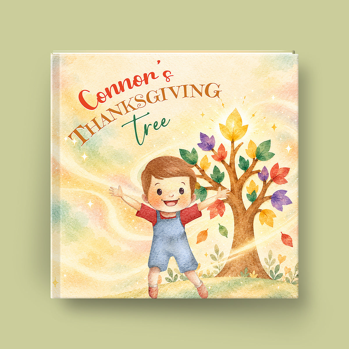 A square hardcover book or gift box cover shown against a muted sage green background. The front artwork features a watercolor-style illustration of a smiling boy standing under a tree with colorful autumn leaves.